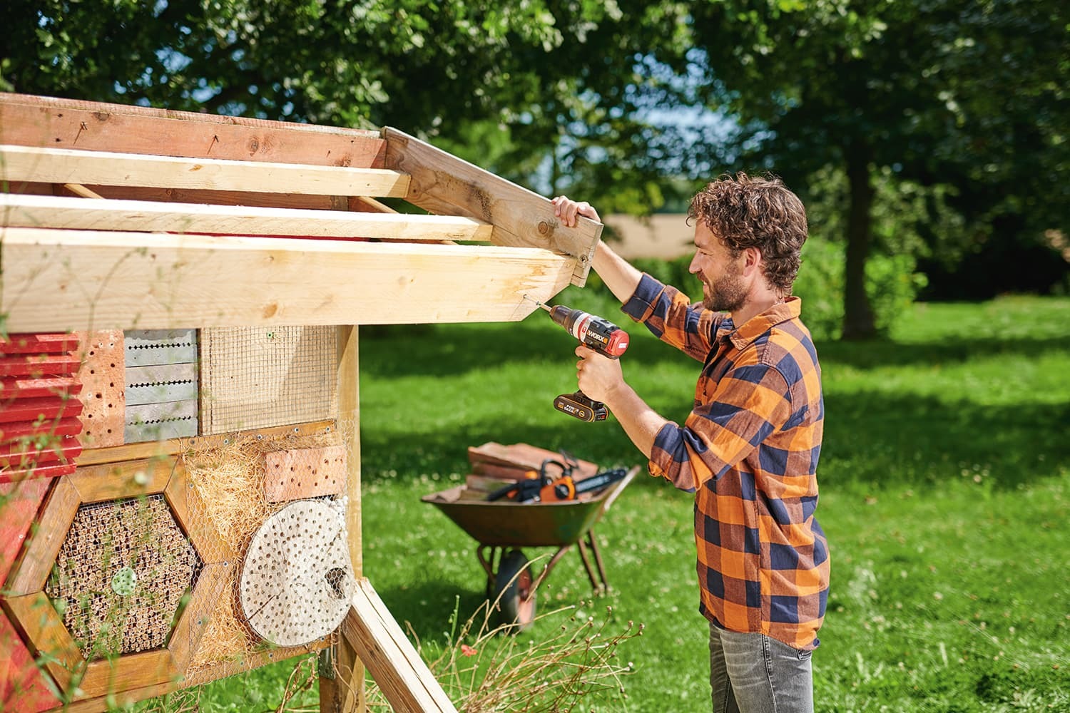 Mann schraubt an einem Holzdach